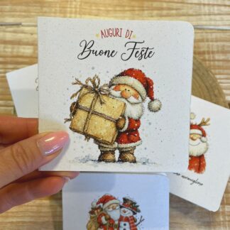 Biglietto di Natale in carta piantabile Auguri di Buone Feste con Babbo Natale, tenuto in mano