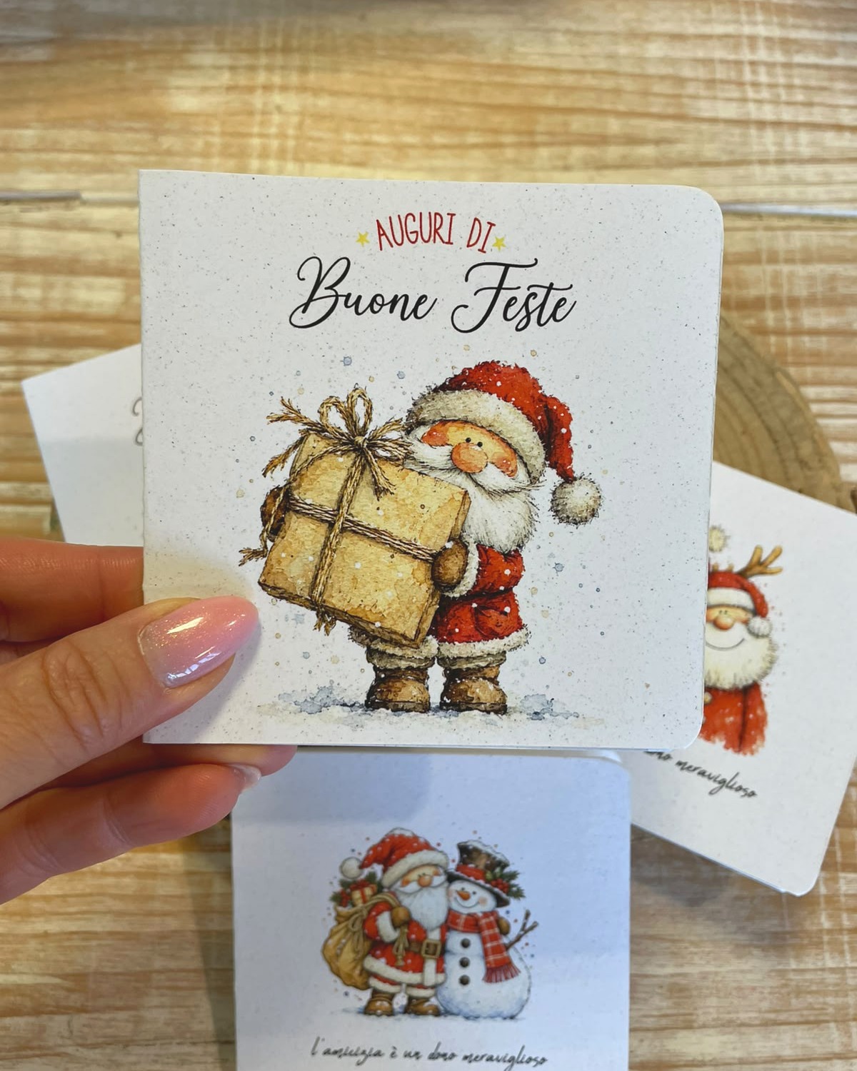 Biglietto di Natale in carta piantabile Auguri di Buone Feste con Babbo Natale, tenuto in mano